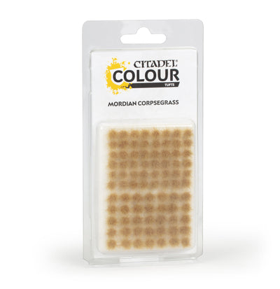 The official retail packaging for Warhammer Colour Mordian Corpsegrass Tufts displaying various sizes of self-adhesive grassy tufts.
