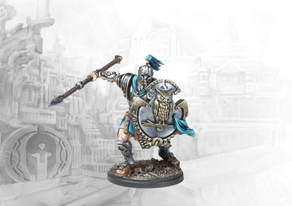 A fully painted City States Dorilates officer miniature for Conquest, holding a spear and a large shield decorated with a prominent owl emblem.