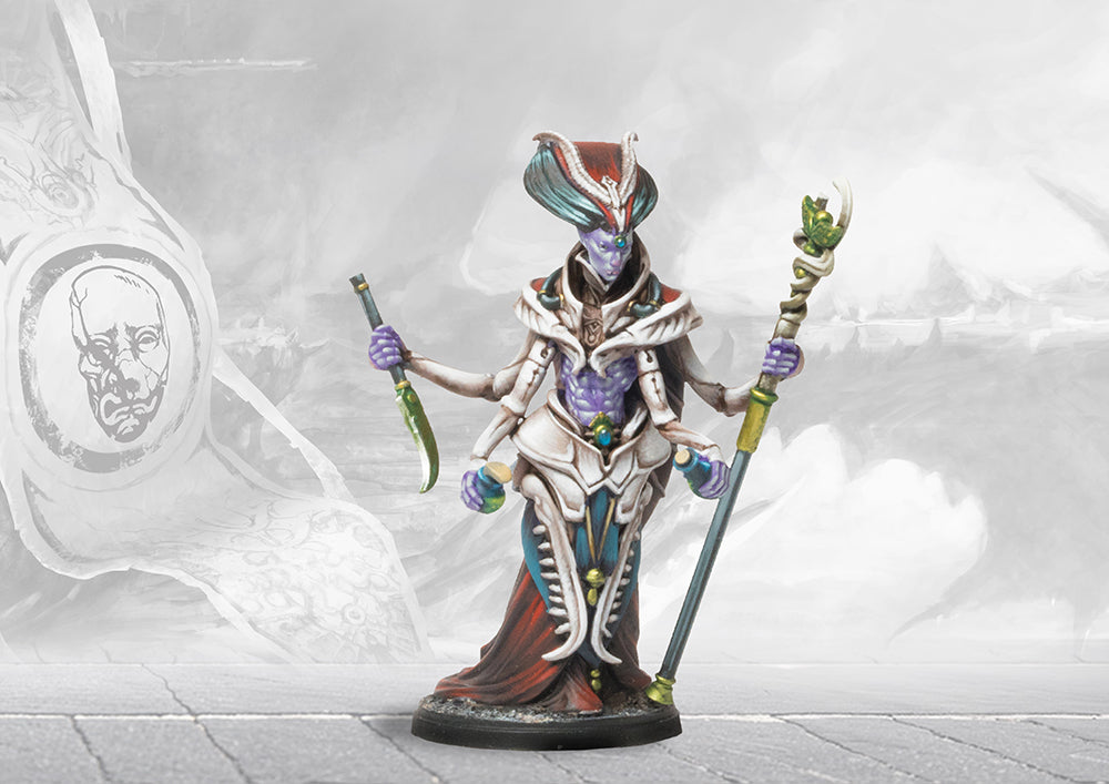 A fully painted Spires Alchemist miniature, featuring four arms, a tall headdress, and holding biomantic vials and a staff.