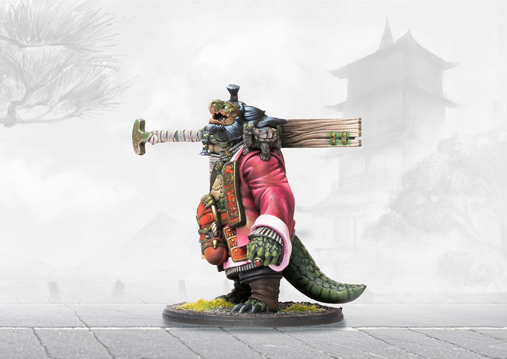 A painted Yoroni turtle-like warrior miniature, wearing a pink robe and carrying a massive wooden paddle over its shoulder.