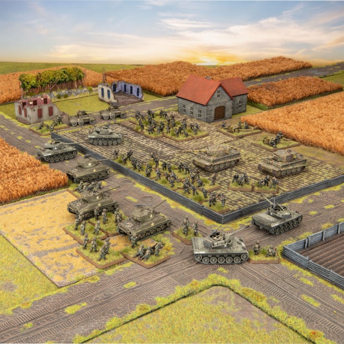 A staged product photo showing the painted US and German tanks, infantry, roads, and ruined buildings included in the Flames of War Fortress Europe starter set.