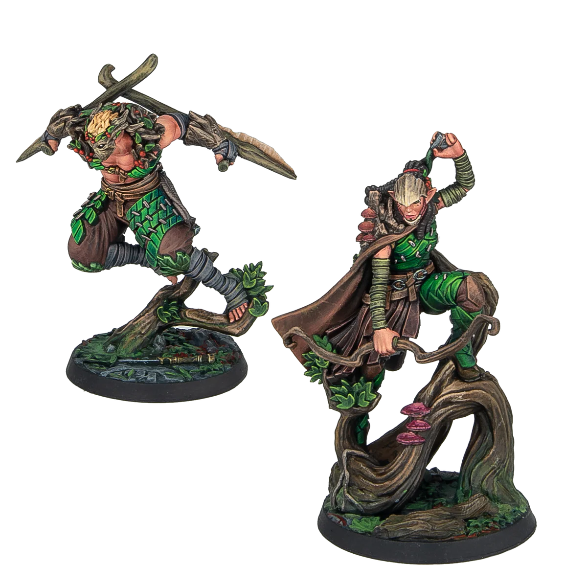 Two painted Warcrow Sÿenann Supports miniatures, featuring dynamic elven warriors leaping from tree branches, armed with blades and bows.
