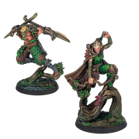 Two painted Warcrow Sÿenann Supports miniatures, featuring dynamic elven warriors leaping from tree branches, armed with blades and bows.