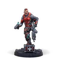 A painted Infinity miniature of the exclusive Alguacil Paramedic, a Nomad trooper in red and black armour holding a medkit.
