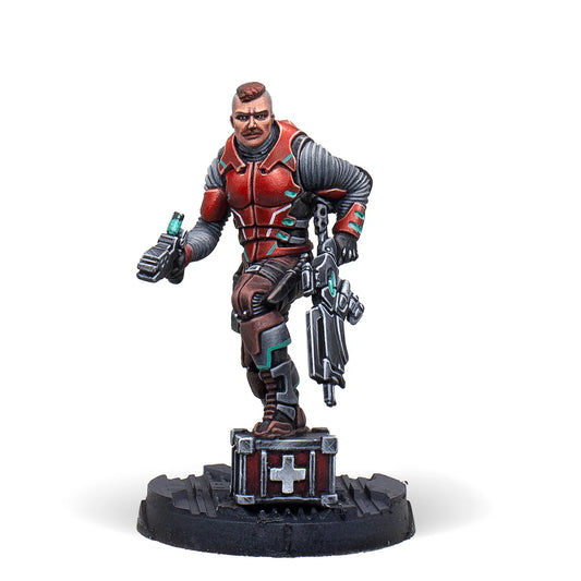 A painted Infinity miniature of the exclusive Alguacil Paramedic, a Nomad trooper in red and black armour holding a medkit.