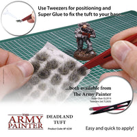 Person applying Deadland Tuft to a miniature figure with text about using tweezers and Super Glue, and branding of The Army Painter.