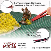 Advertisement for The Army Painter's Meadow Flowers product with tweezers and super glue on a grid surface.