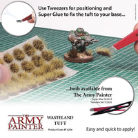 Advertisement for The Army Painter Wasteland Tuft with tools and text on a grid background