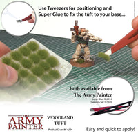 Advertisement for The Army Painter Woodland Tuft with tools and product packaging on a grid background.