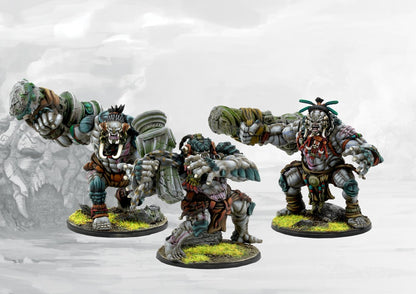 Three painted W'adrhŭn Warbred miniatures in dynamic attacking poses, showcasing the powerful, muscular physique and tribal war gear.